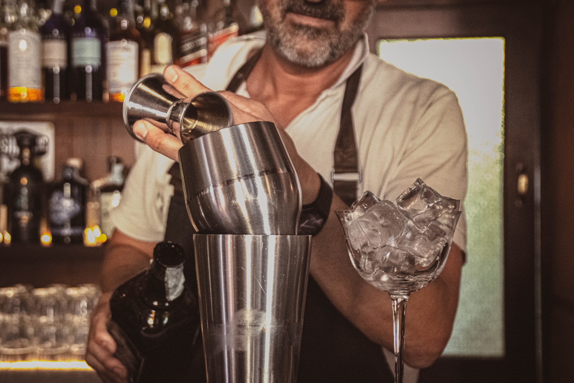 a man is making a drink at a bar
